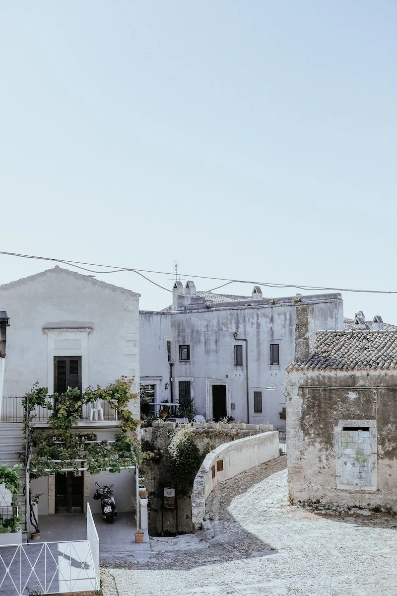 a white building with a balcony next to a street