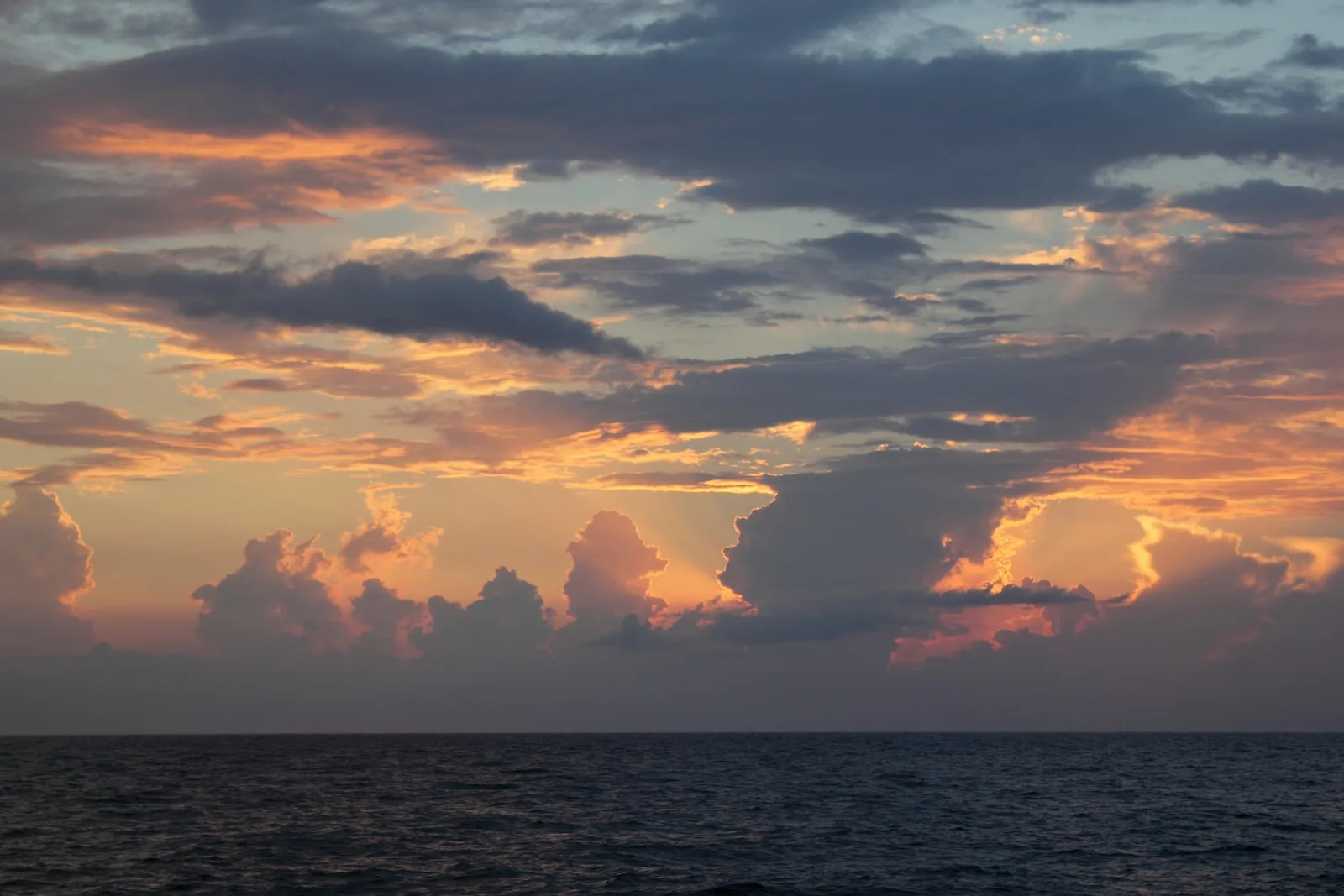 body of water under cloudy sky during sunset