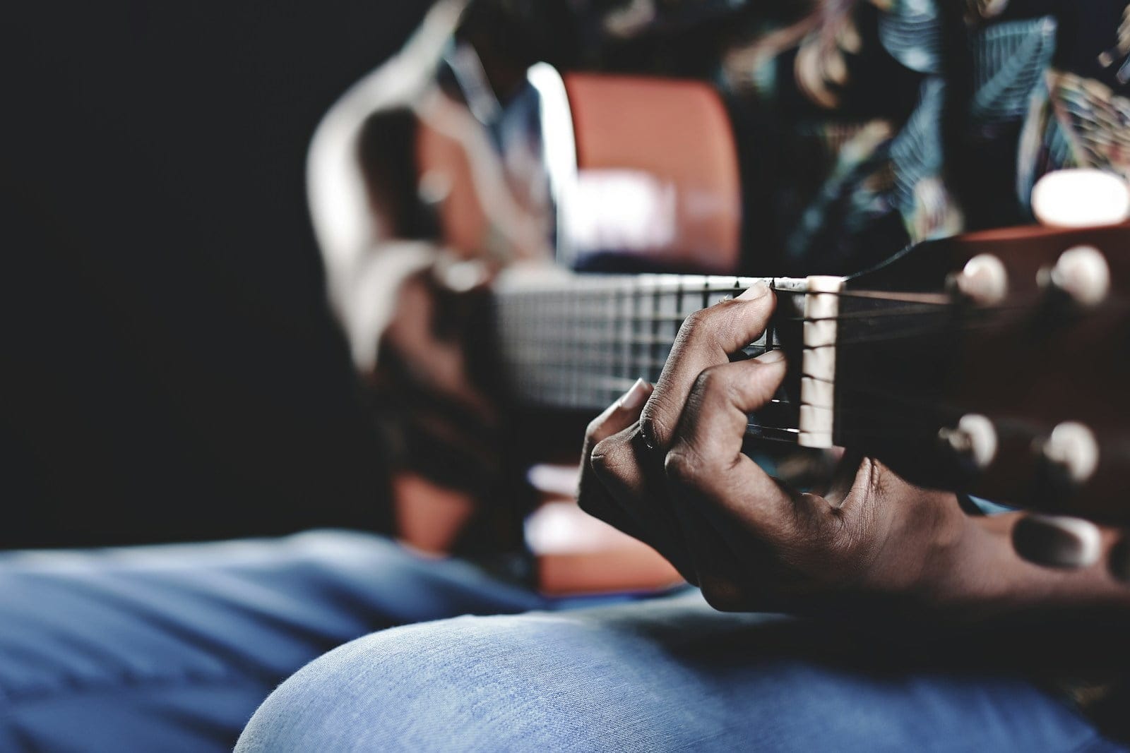 person playing a brown guitar