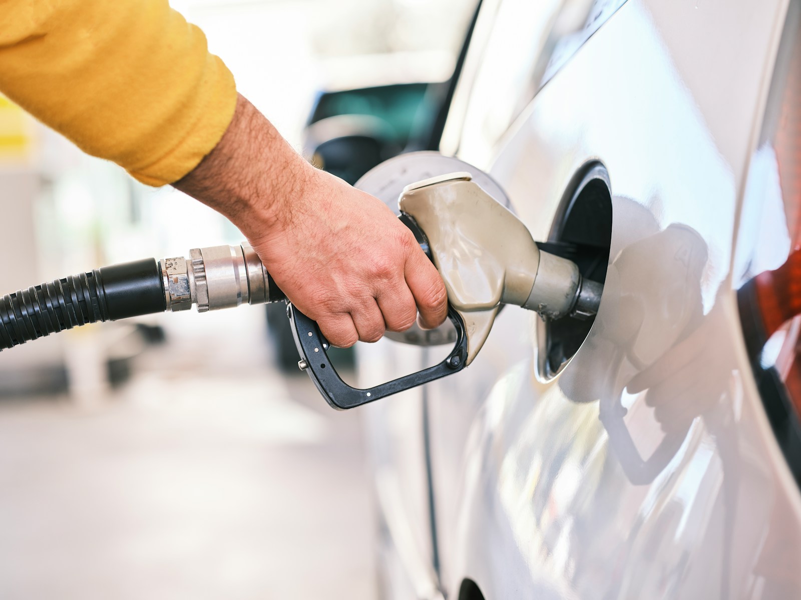 a man pumping gas into his car at a gas station